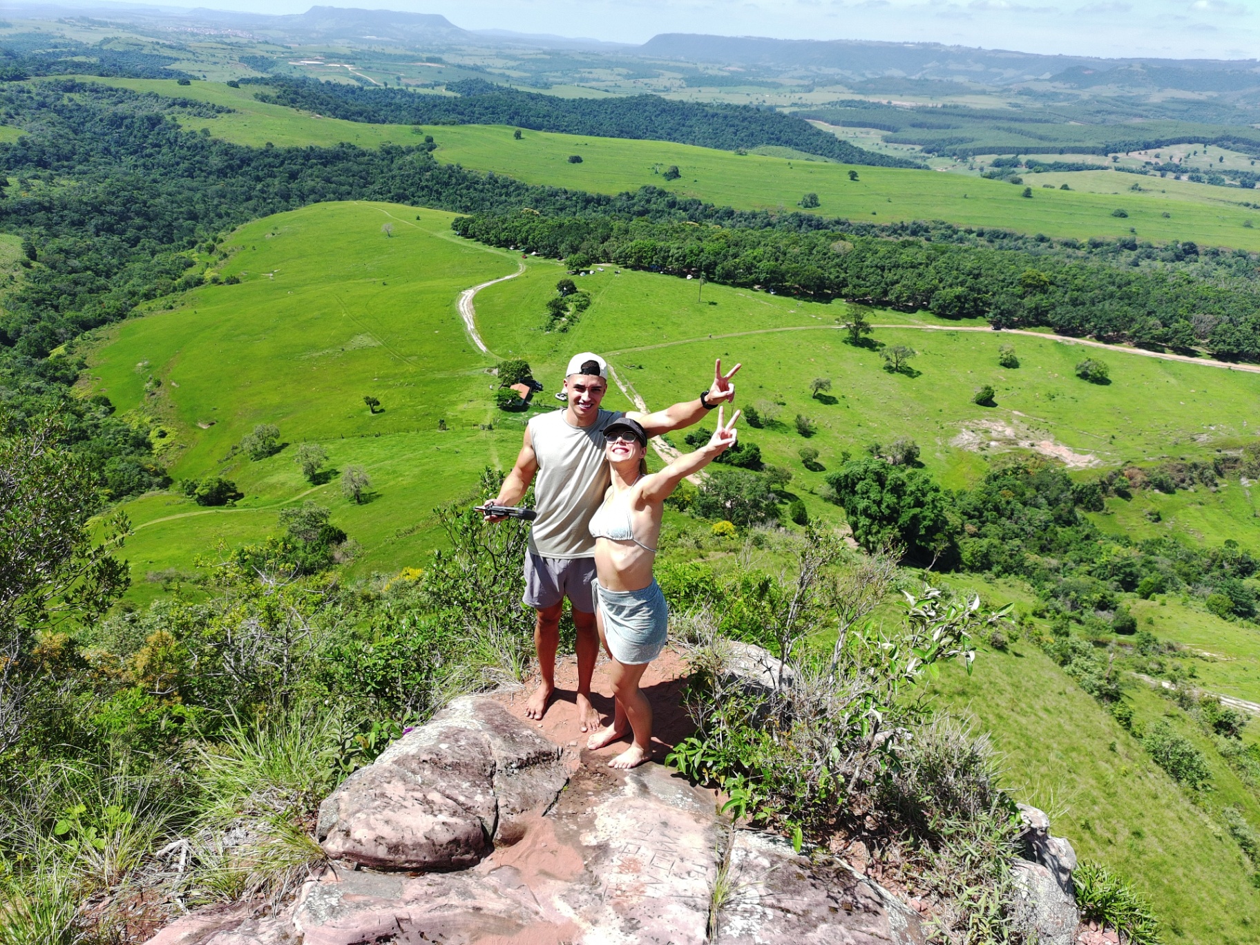 Casal no topo da pedra com vista panorâmica